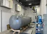 Large industrial pressure tank installed inside a commercial mechanical room